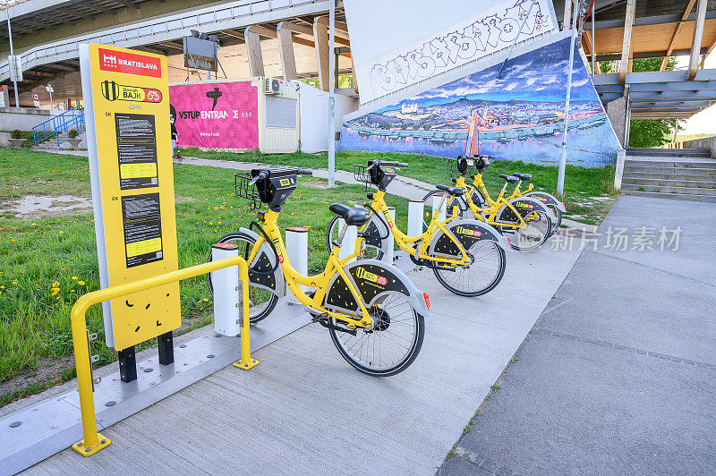 布拉迪斯拉发(斯洛伐克)â2020年4月20日:黄色的公共自行车被锁在多瑙河岸边的停靠站——共享单车